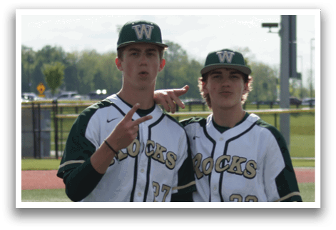 Two baseball players standing on a field. Description generated by AI