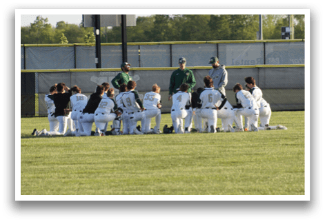 A group of baseball players kneeling on the field. Description generated by AI