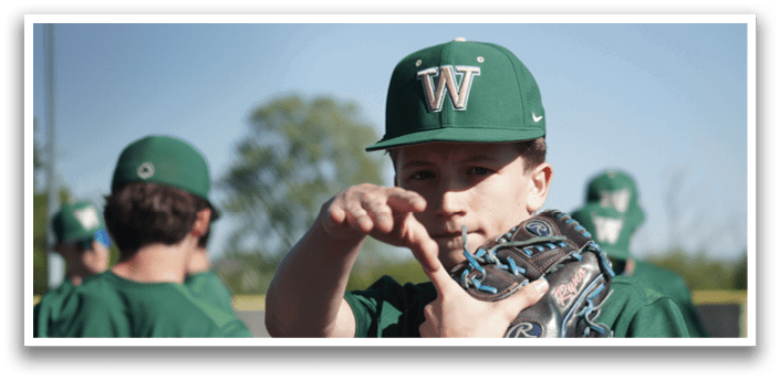 A baseball player wearing a helmet and sitting on the ground. Description generated by AI