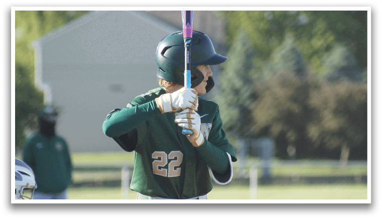A boy wearing a green shirt and red pants is playing baseball. Description generated by AI