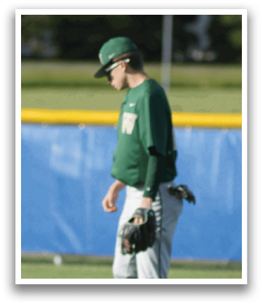 A baseball player in a green shirt and white pants is throwing a ball. Description generated by AI
