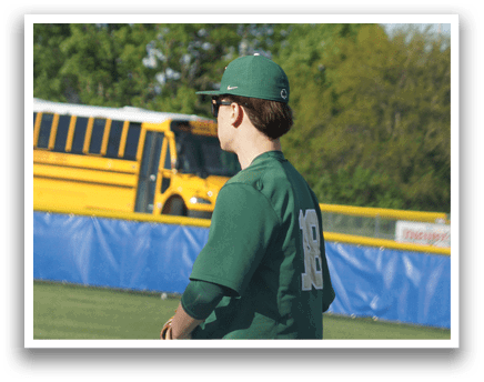 A baseball player in a green and white uniform is holding a bat and getting ready to swing. Description generated by AI