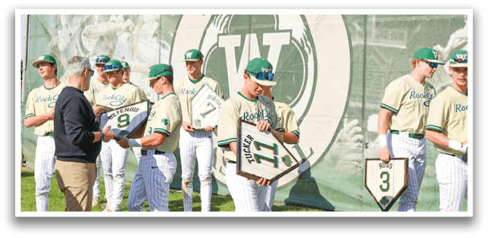 Three baseball players wearing white and green uniforms. Description generated by AI