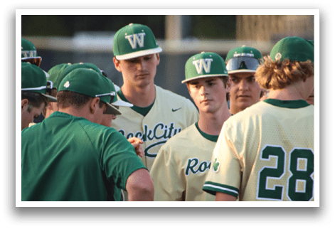 A baseball player wearing a green helmet and green pads. Description generated by AI