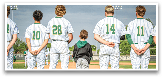 A baseball player wearing a green and white uniform is swinging a bat. Description generated by AI