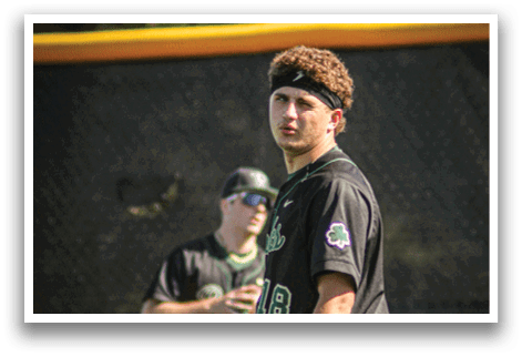 A baseball player wearing a green helmet and green pads. Description generated by AI