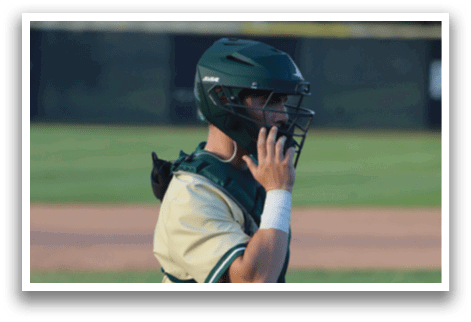 A baseball player wearing a green helmet and green pads. Description generated by AI