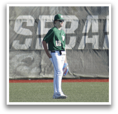 A baseball player wearing a white uniform and a green helmet. Description generated by AI