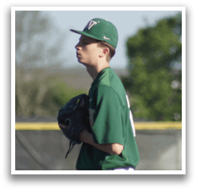 A baseball player wearing a white uniform and a green helmet. Description generated by AI