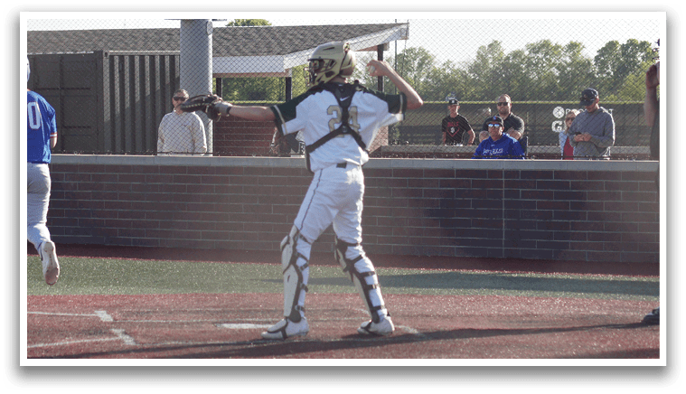 A boy wearing a green shirt and red pants is playing baseball. Description generated by AI