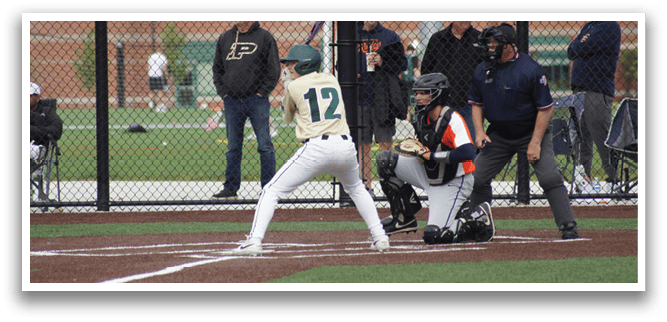 A baseball player wearing a green and white uniform is running towards a base. Description generated by AI