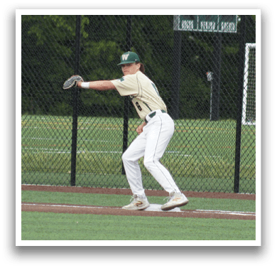 A baseball player in a green and white uniform is standing on the field. Description generated by AI