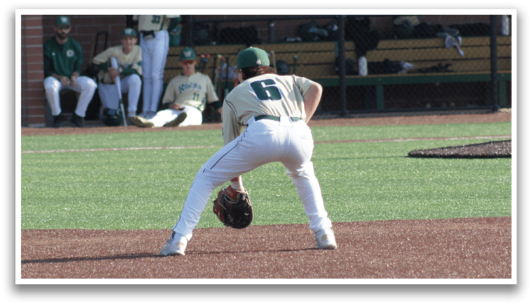 A boy wearing a green shirt and red pants is playing baseball. Description generated by AI