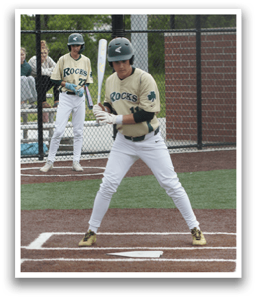 A baseball player in a green shirt and white pants is throwing a ball. Description generated by AI