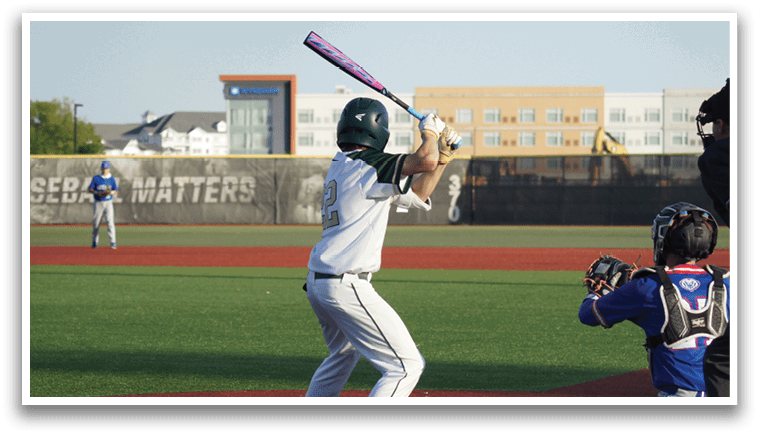 A boy wearing a green shirt and red pants is playing baseball. Description generated by AI