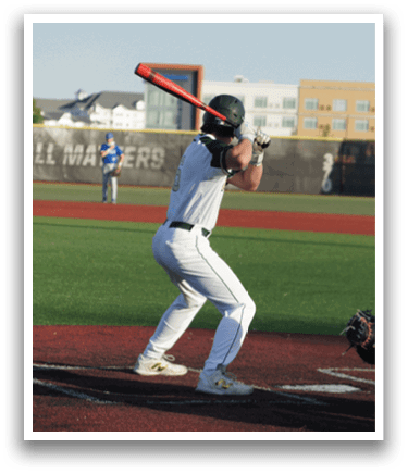 A baseball player in a green shirt and white pants is throwing a ball. Description generated by AI