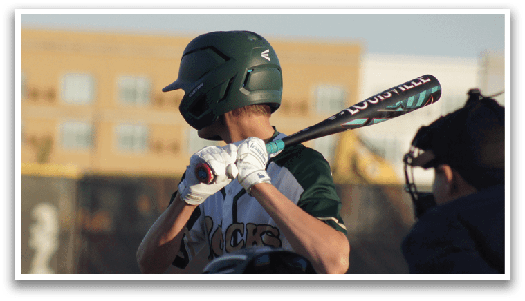 A boy wearing a green shirt and red pants is playing baseball. Description generated by AI