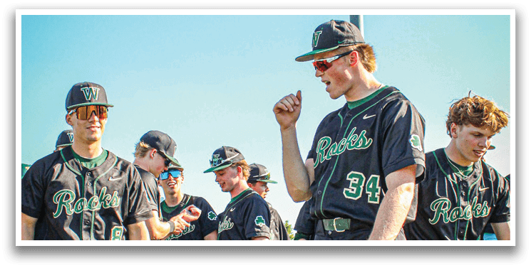 A man wearing a baseball uniform is laughing. Description generated by AI