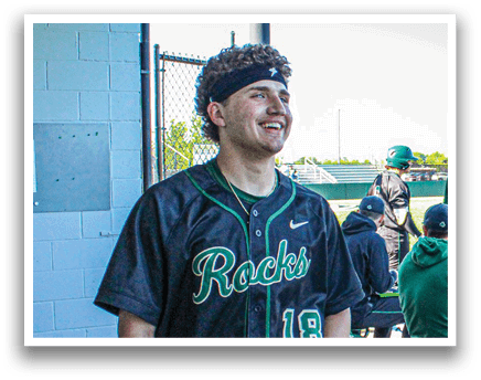 A baseball player in a yellow and green uniform is swinging a bat. Description generated by AI