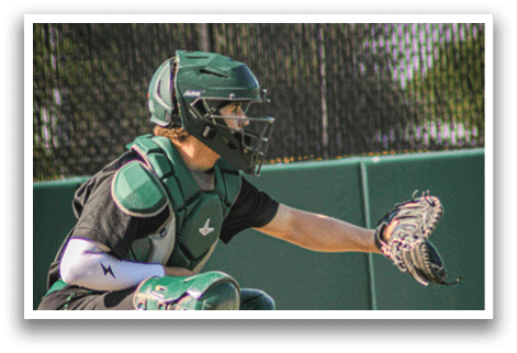 A baseball player wearing a green helmet and green pads. Description generated by AI