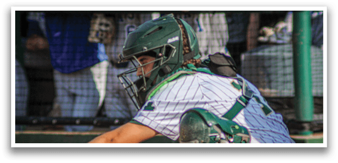 A group of baseball players wearing green and white uniforms. Description generated by AI
