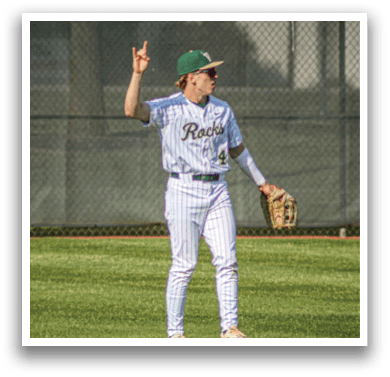 A baseball player wearing a white uniform and green sleeves is throwing a ball. Description generated by AI