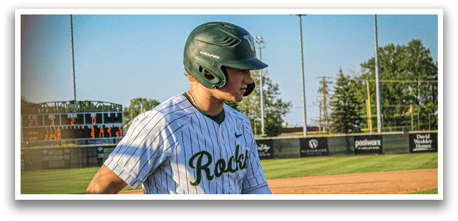 A baseball player wearing a green and white uniform is swinging a bat. Description generated by AI