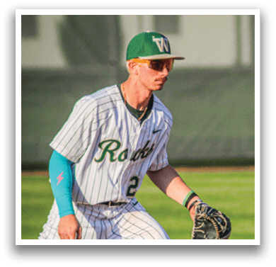 A baseball player wearing a white uniform and a green hat. Description generated by AI