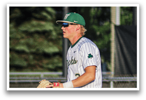 A baseball player wearing a green and white uniform with the number 6 on the back. Description generated by AI
