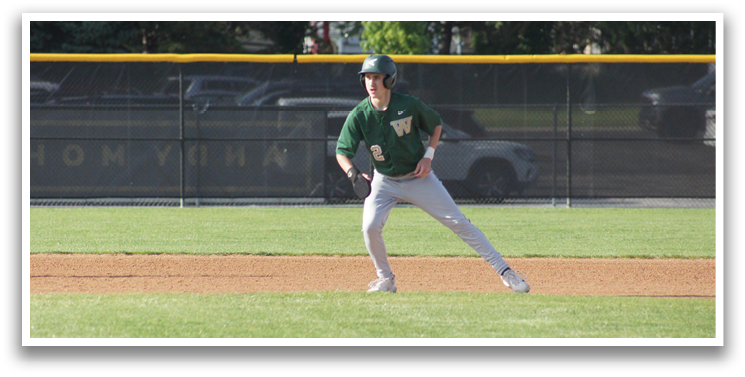 A baseball player wearing a green and white uniform is running on the field. Description generated by AI