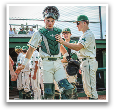 A baseball player wearing a helmet and green and white uniform. Description generated by AI