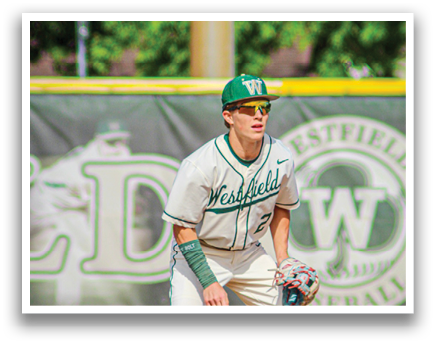A baseball player in a white uniform is standing on the field. Description generated by AI