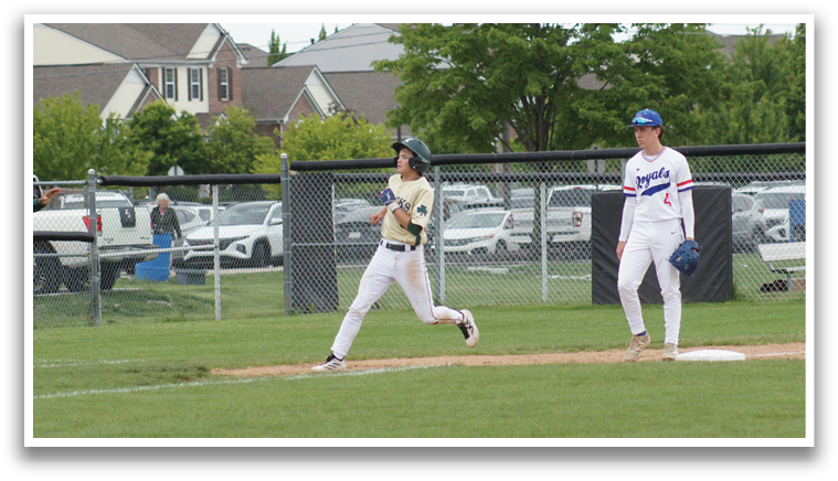 A boy wearing a green shirt and red pants is playing baseball. Description generated by AI