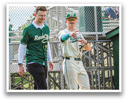 Two men walking on a baseball field. Description generated by AI
