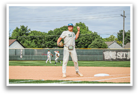 A baseball player in a white uniform is standing on the field. Description generated by AI