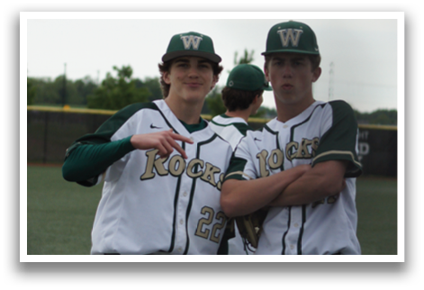Two baseball players standing on a field. Description generated by AI