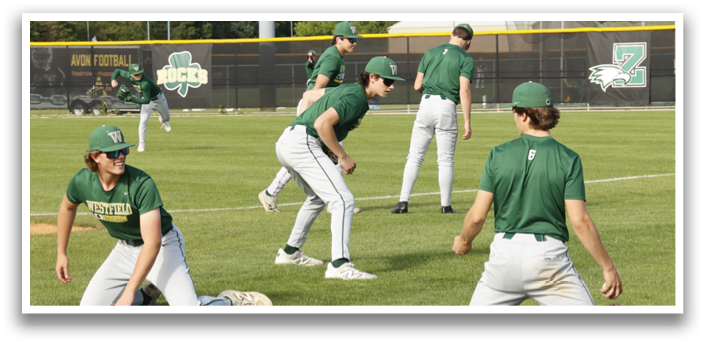A group of baseball players in green and white uniforms are on a field. Description generated by AI