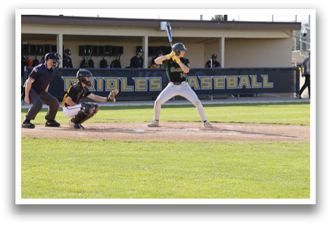 A baseball player is holding a bat and getting ready to hit the ball. Description generated by AI