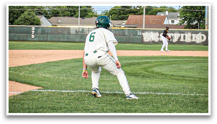 A baseball player in a white uniform is crouching on the field. Description generated by AI