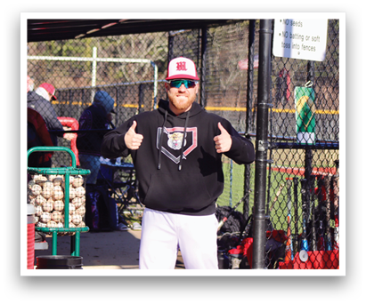A man in a black hoodie is giving a thumbs up in front of a baseball field. AI generated content