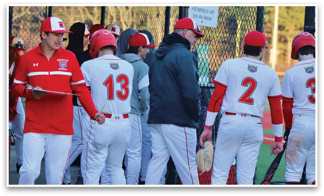 A group of baseball players wearing red and white uniforms. Description generated by AI