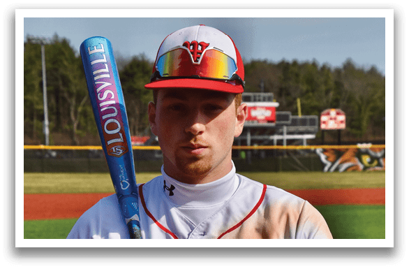 A baseball player holding a bat. Description generated by AI