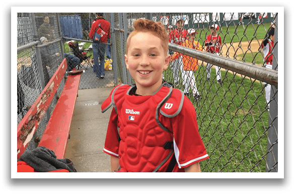 A boy wearing a baseball glove and a red shirt. Description generated by AI