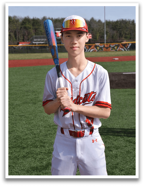 A baseball player in a white uniform holding a bat. Description generated by AI