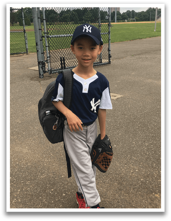 A young boy wearing a baseball uniform and holding a baseball glove. Description generated by AI
