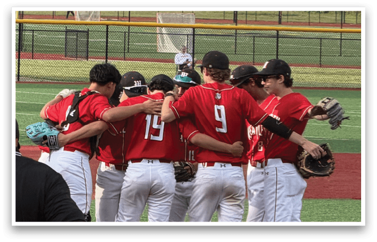 A group of baseball players huddled together on the field. Description generated by AI