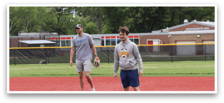 Two men standing on a baseball field. Description generated by AI
