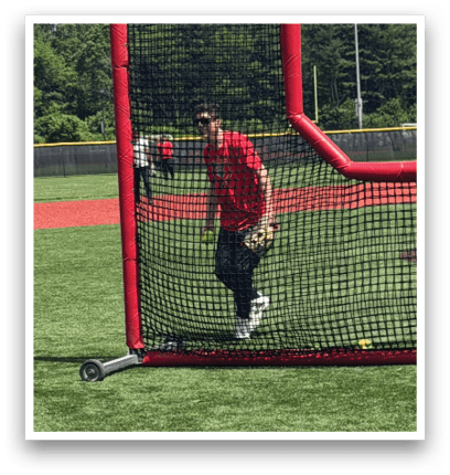 A man is swinging a bat at a ball in a batting cage. Description generated by AI