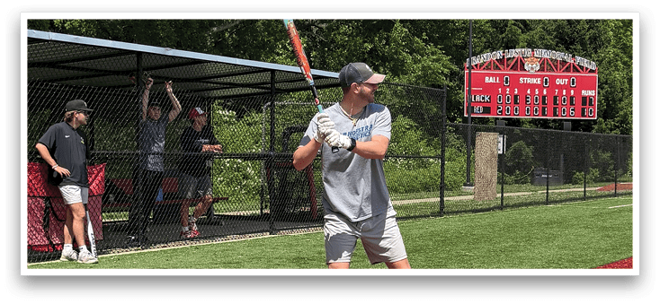 A baseball player in a grey shirt and white shoes is swinging a bat at a ball. Description generated by AI