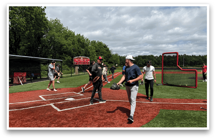 A baseball field with a group of people playing. Description generated by AI